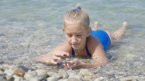 Cute Child Girl Bathes in Sea. Family Vacation Concept.