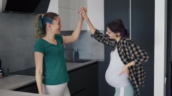 Pregnant Woman and Her Mother in Kitchen Have Fun and Dancing