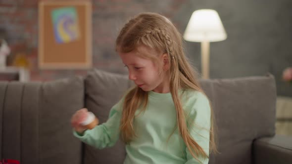 Pretty Little Girl with Blonde Hair Shakes Bottle with Paint