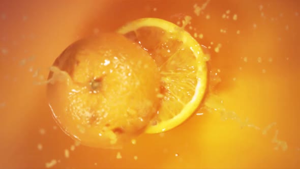 Orange Fruit Falling on Juice with Splash and Divided in Half