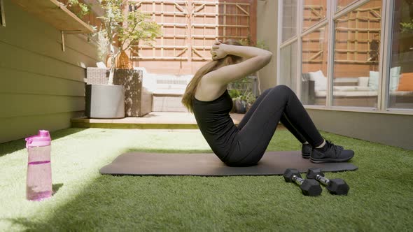 A white woman doing sit ups in her back yard. 4k60