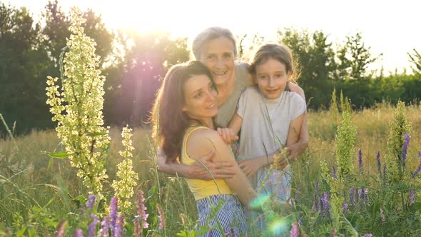 Cute Child Girl with Her Young Mother and Senior Grandmother are Having Picnic During Summer Outdoor