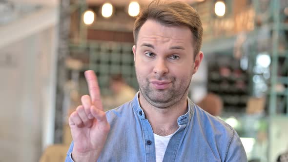 Portrait of Casual Man Shaking Finger As No Sign 