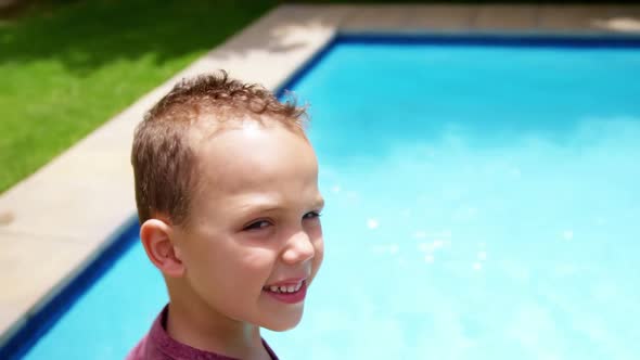 Boy standing next to swimming pool