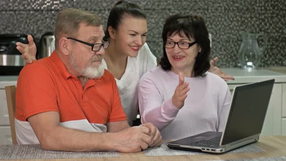 Beautiful Young Woman Is Explaining To Her Elderly Parents How To Shop and Various Payments Online