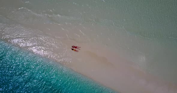 Romantic boy and girl in love dating on vacation spend quality time on beach on white sand 4K backgr