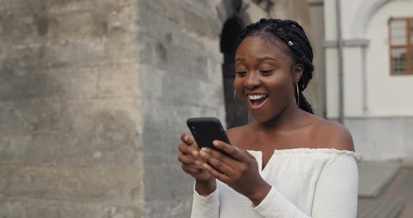 Young Woman Using Smartphone, Looking Shocked and Happy