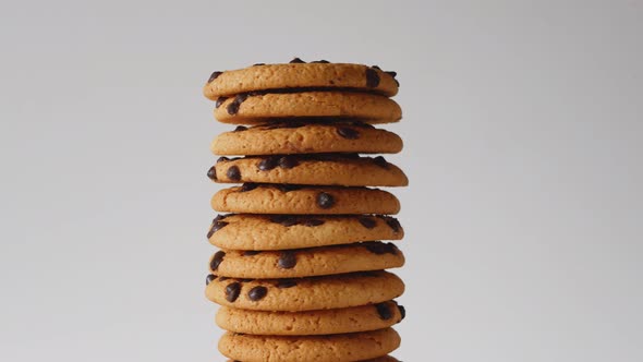 A stack of chocolate chip cookies rotate on a light background. American cookies close-up