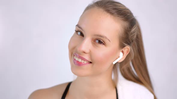 Closeup Pretty Fit Lady with Beauty Skin Wearing Headphones Isolated at Light Studio Background