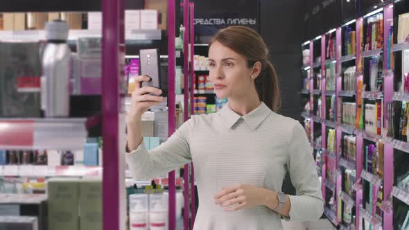 Woman Taking Photos Of Beauty Products In Cosmetics Store