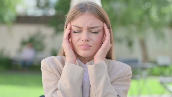 Outdoor Portrait of Young Businesswoman Having Headache