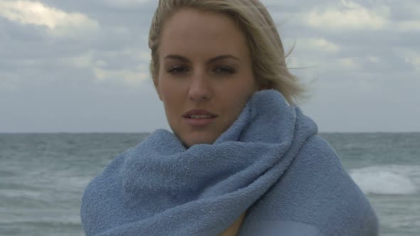 Female wrapping a towel around her on a beach