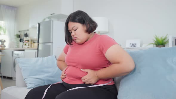 Depressed unconfident girl sit in living room look at tummy with ashamed feeling want to lose weight