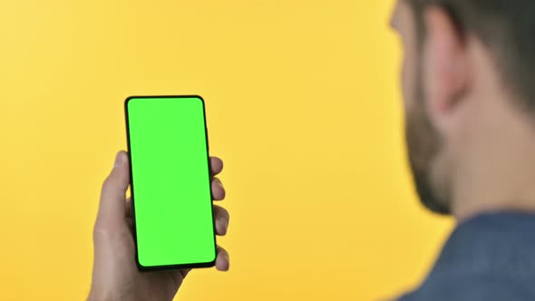 Man Using Smartphone with Chroma Screen, Yellow Background