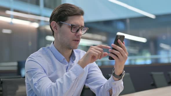 Young Man Reacting to Loss on Smartphone