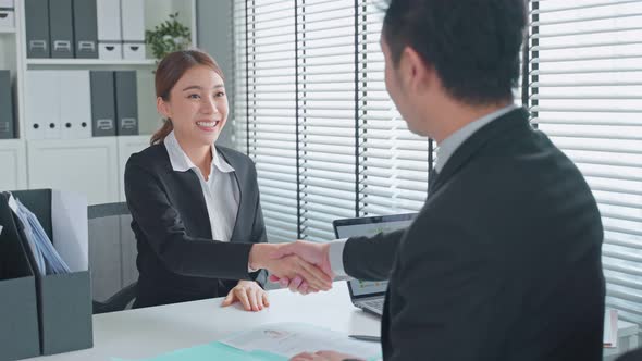 Female employee shake hands with human resources manager businessman after job interview.