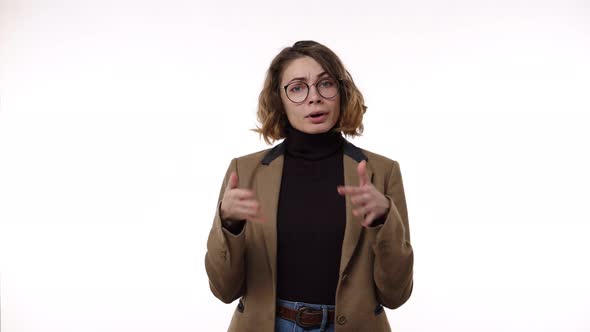 Portrait of Young Woman in Jacket and Jeans Shows How Hot It is with Hand Gestures on an Isolated