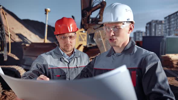 Main Architect Looking on Paper Plan of Construction Site Outdoor at Industrial Background