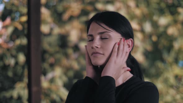 Young woman doing warm-up on terrace. warm-up for the ears. Head massage