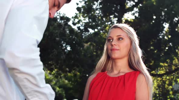 Smiling man offering engagement ring while proposing to woman