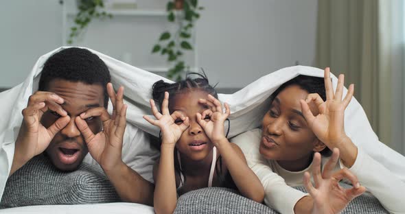 African American Ethnic Black Mixed Race Family Having Fun Indoor Lying on Sofa Covered with Blanket