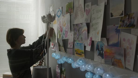 Girl Putting Drawing on Wall in Hospital Room