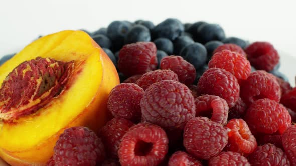 Assorted fruits and berries on a white background rotation 360. Summer fruit raspberry blueberry