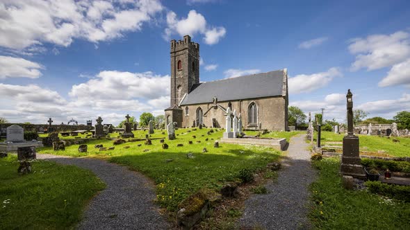 Time lapse of historical cemetery and medieval church in rural Ireland with passing clouds and sunsh