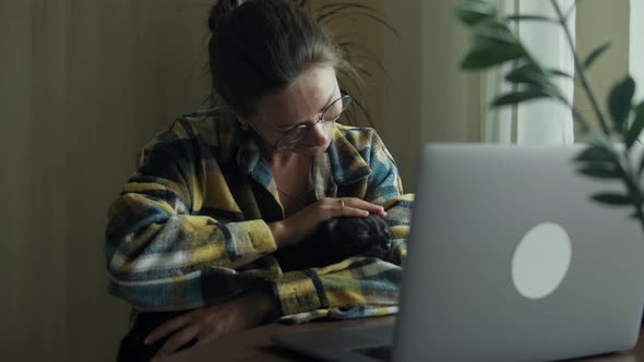 Woman Petting Her Cat At Home Office