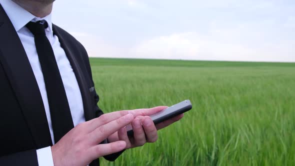 Agronomist Working with Tablet Computer Outdoors in Field