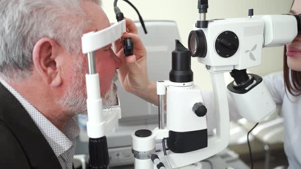 Ophthalmologist Examination of Elderly Man with Slit Lamp