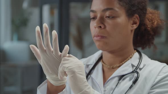 Serious Woman Physician Adjusting Medical Glove