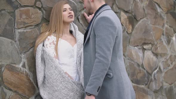 Couple Stands Near the Wall