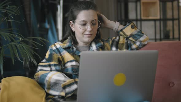 Woman Wearing Round Glasses Works With Laptop At Home