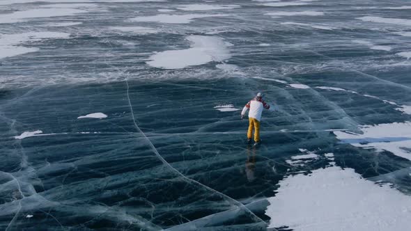 Aerial View of Man Skating on Lake Baikal Covered By Ice