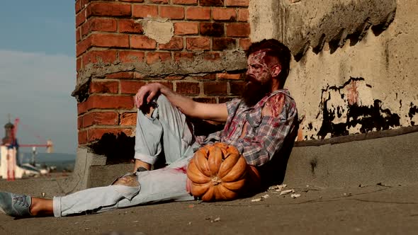 Slow Motion. Terrible Bloody Zombie Man with Carved Pumpkin. Horror. Halloween Concept.
