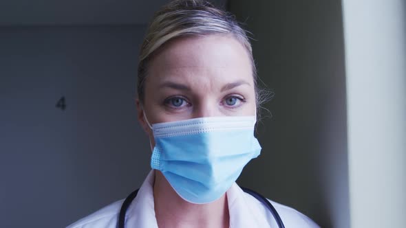 Portrait of caucasian female doctor wearing face mask at hospital