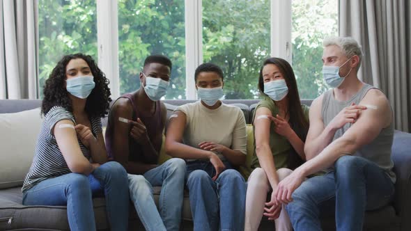 Group of diverse young people showing their vaccinated shoulders at home