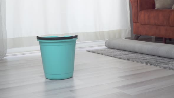 A Woman in Gloves Takes a Bucket of Water After Cleaning