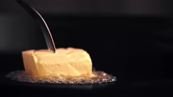 Super Slow Motion a Piece of Butter Melts in a Frying Pan with Air Bubbles