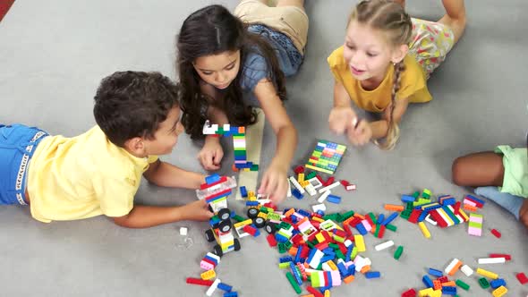 Kids Laying on the Floor and Playing with Toys