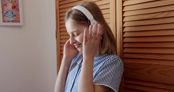 Cute Girl with White Wireless Headphones Listening to Music