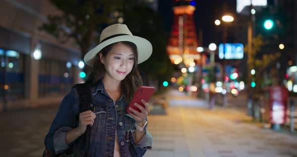 Woman use of mobile phone in Tokyo city at night 