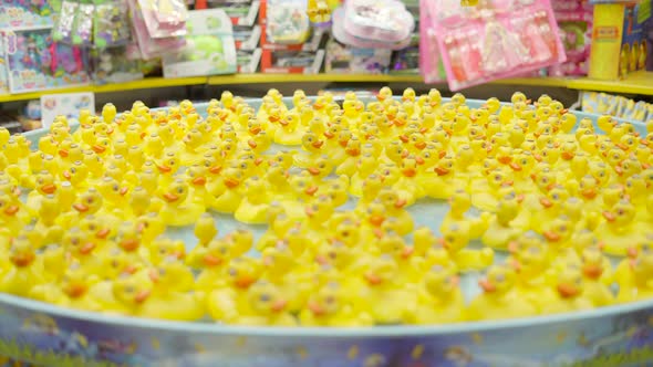 Small Plastic Yellow Ducklings Toy Floating Around on Water at Toys Store for Children at Valencia