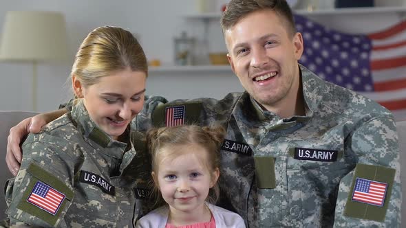 Military Couple With Daughter Smiling in Camera