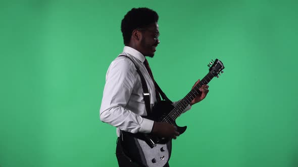 Portrait of Young African American Man Smiling and Playing Electric Guitar