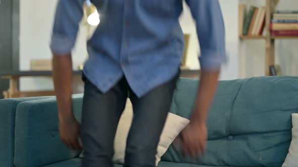 Young African Man Closing Laptop Going Away From Sofa 