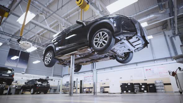 The Work of an Automatic Lift in a Car Workshop