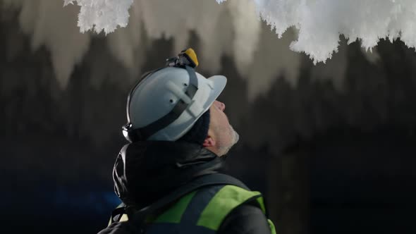 Excited Bearded Man Turning Looking Around at Frost Snow in Ice Cave Outdoors