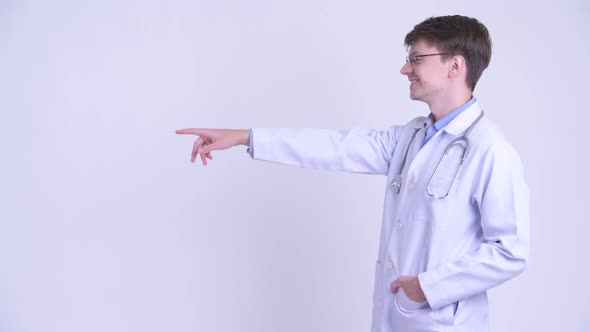 Profile View of Happy Young Man Doctor Directing and Pointing Finger